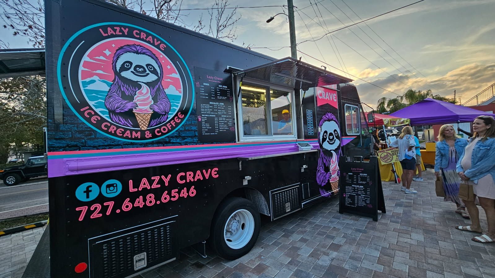 The Lazy Crave truck serving a crowd at a sunset street market